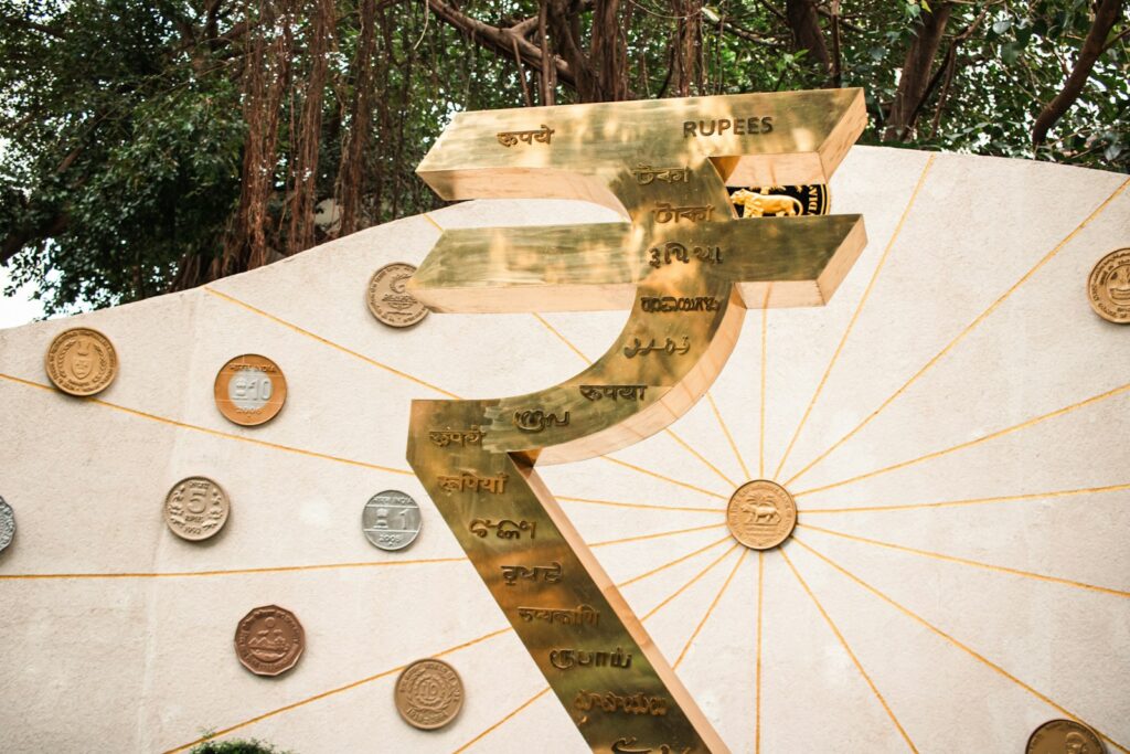 A monument displays the symbol for the indian rupee.