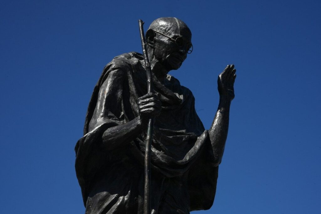 Statue of mahatma gandhi against a clear blue sky